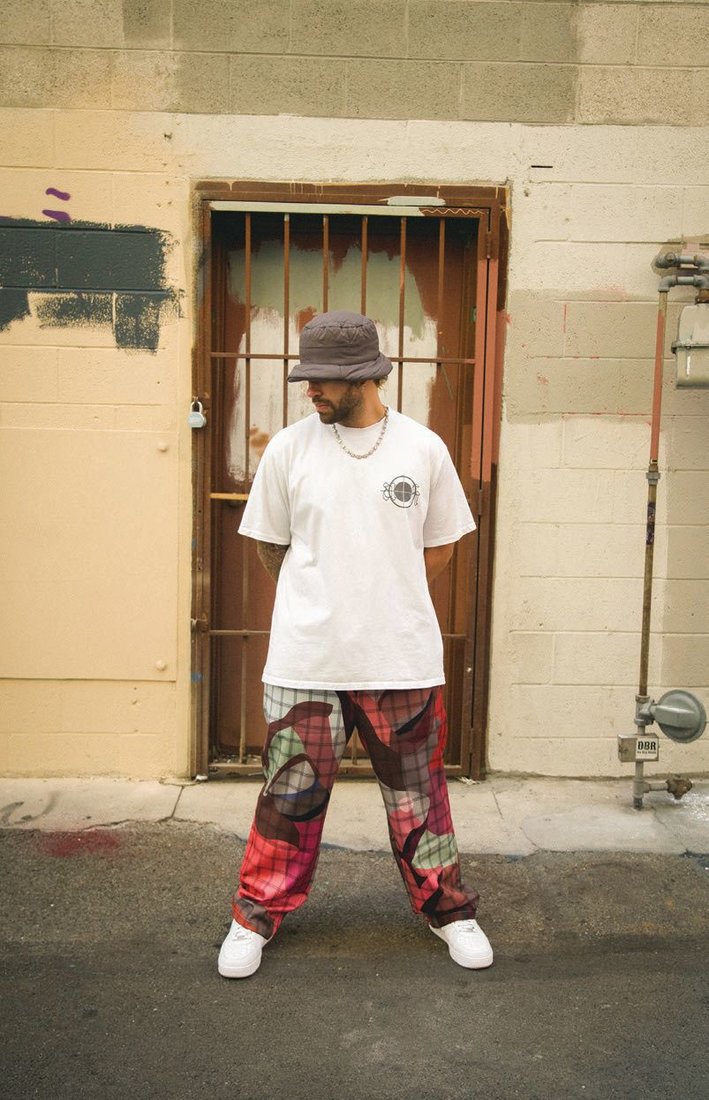 Gallery Dept. jeans, gallerydept.com; his own sunglasses. Tombogo hat, tombogo.com  AskYourself T-shirt, stylist’s own; Kidsuper pants, kidsuper.com; his own jewelry and sneakers. PHOTOGRAPHED BY DEATHTOGIAN STYLED BY MARIO RANGEL